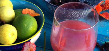 pink beverage with a bowl of fruits on the side